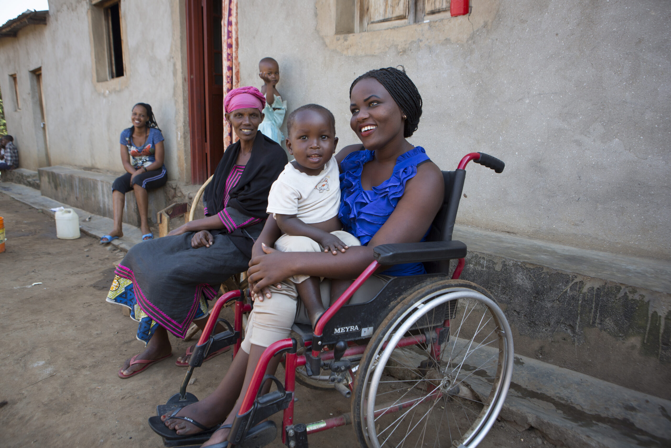 Tatu Mugisha (20) at home with family members.