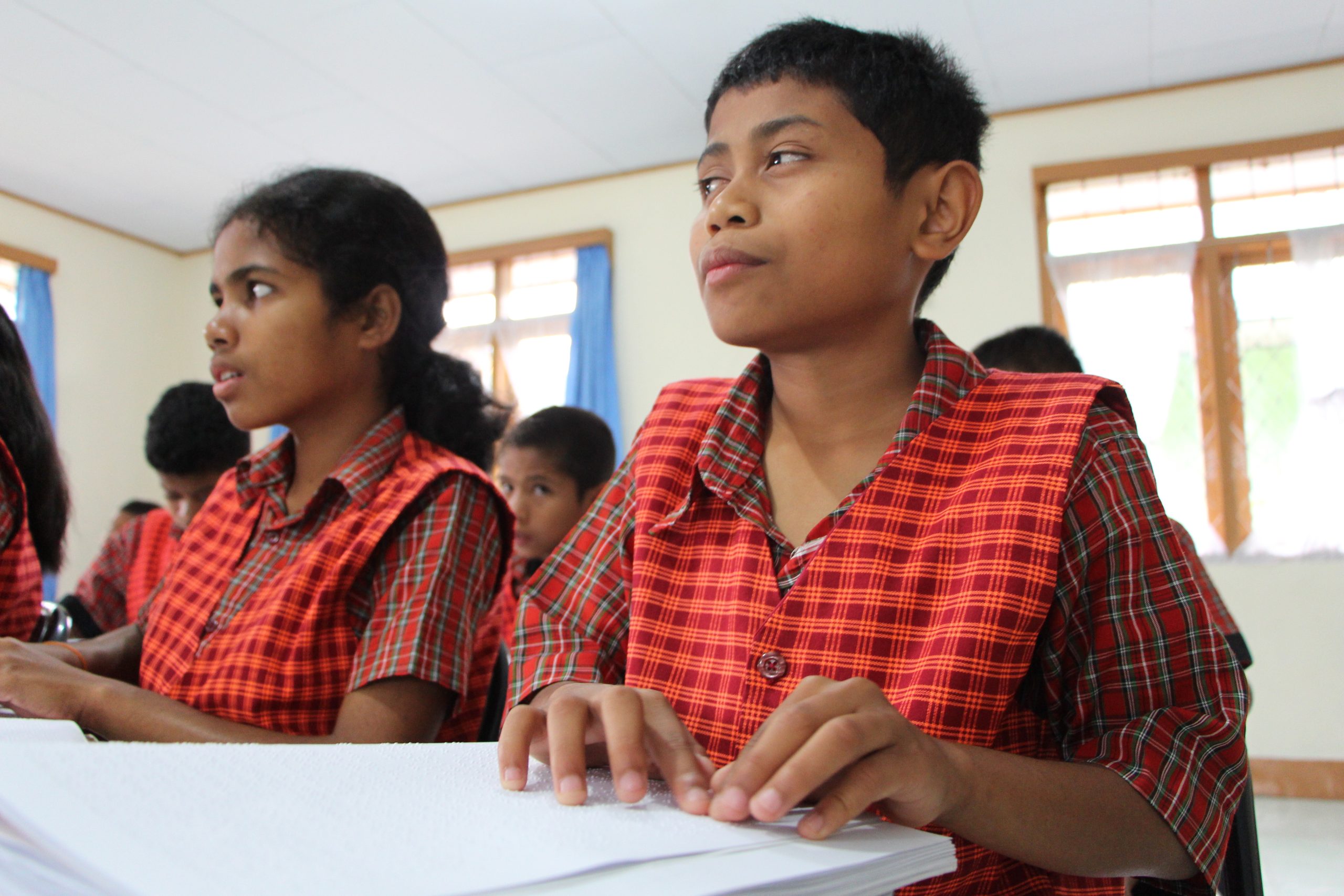 Alif leest uit een boek in Braille